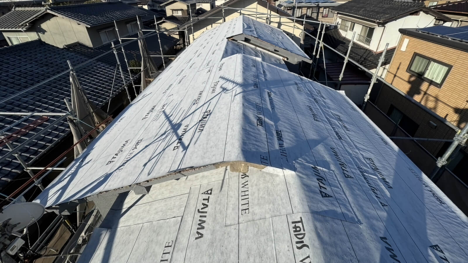 新しい屋根材を施工する屋根葺き替え作業風景